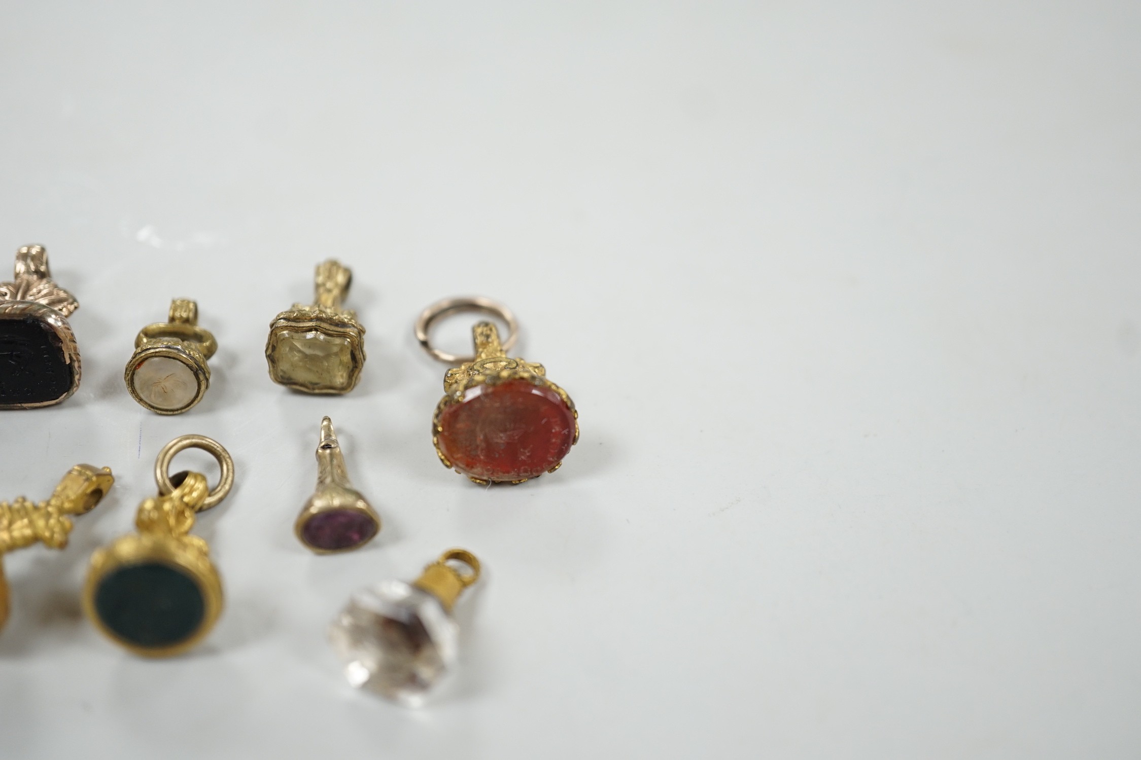 A collection of twelve small 19th century mainly yellow metal fob seals, with assorted matrices including bloodstone, amethyst, citrine and carnelian, largest 22mm.